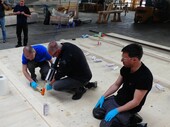 Mitarbeiter von TS3 und Timbatec verkleben die Arbeitsplattform